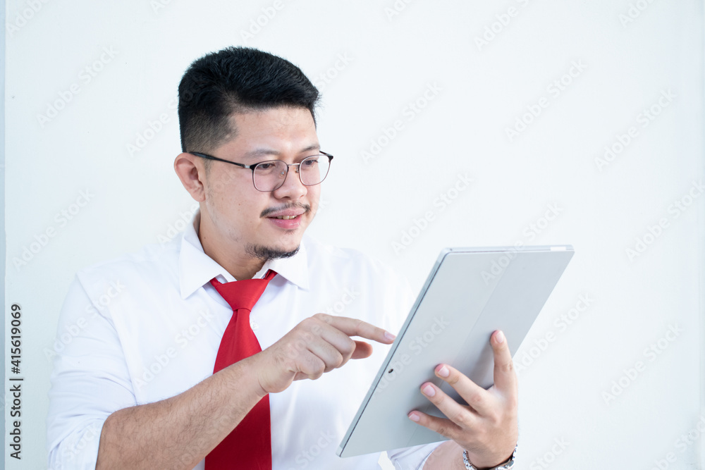 Expert in digital technologies. Cheerful young man in formal wear working on digital tablet and smiling while standing isolated on white background Expert in digital technologies. Cheerful young man in formal wear working on digital tablet and smiling while standing isolated on white background