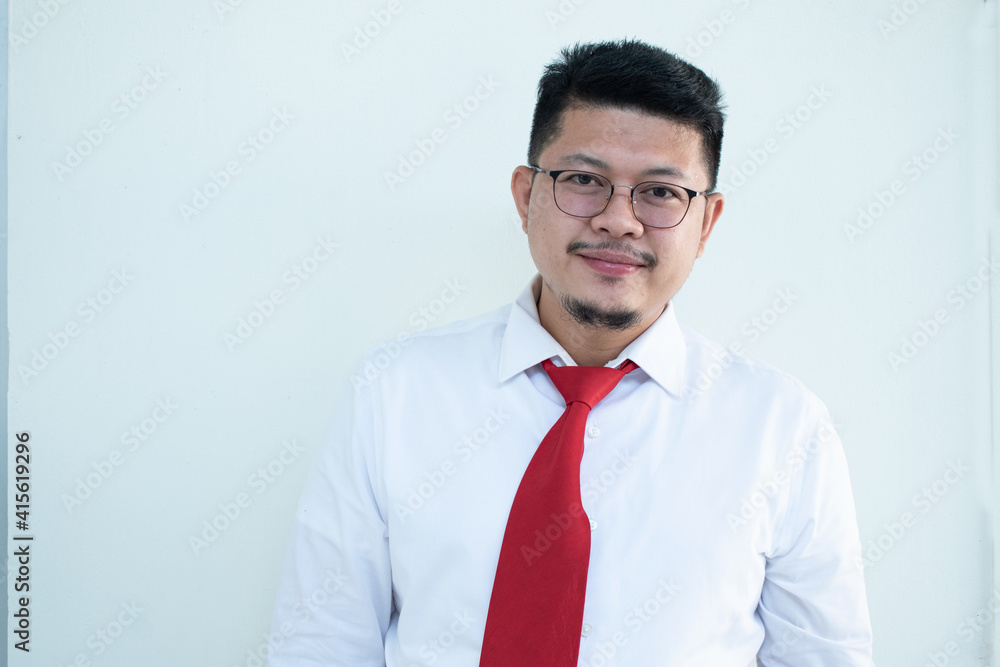 Portrait of a handsome Asian man wearing glasses. Wear a white shirt and red tie. Portrait of a handsome Asian man wearing glasses. Wear a white shirt and red tie.