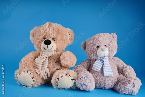 Close up of cute teddy bears. Soft plush toys on blue background.