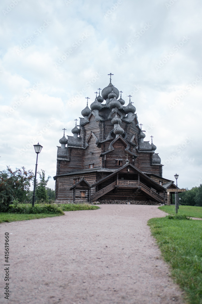 Leningrad region, Vsevolozhsky district, Russia, 29 August 2020: Wooden orthodox Pokrovskaya church in Nevsky forest park in summer cloudy weather. Complex 