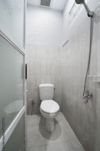 Nicely decorated bathroom with the toilet sit and partition glass for shower bathroom