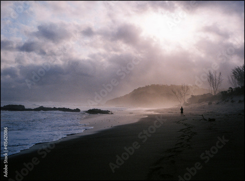 a person walking on a moody looking beach