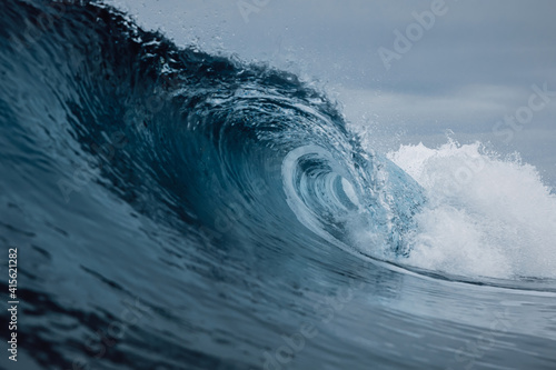 Perfect sea waves with blue water cloudy sky.
