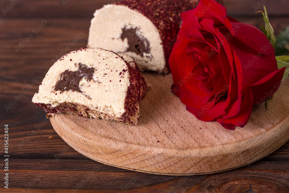 Eastern sweetness halva with chocolate and rose on wooden background