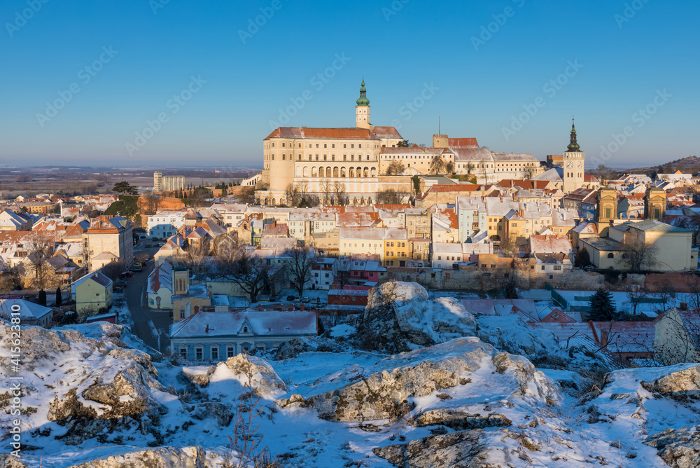 Obraz premium Scenic panorama romantic view of beautiful historical landmark Mikulov Castle and historical city centre of Mikulov in South Moravia, Czech Republic. Castle at sunrise near Austria border. Winter time