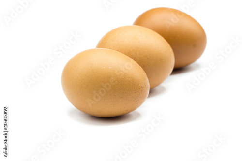 three brown eggs isolated on white background