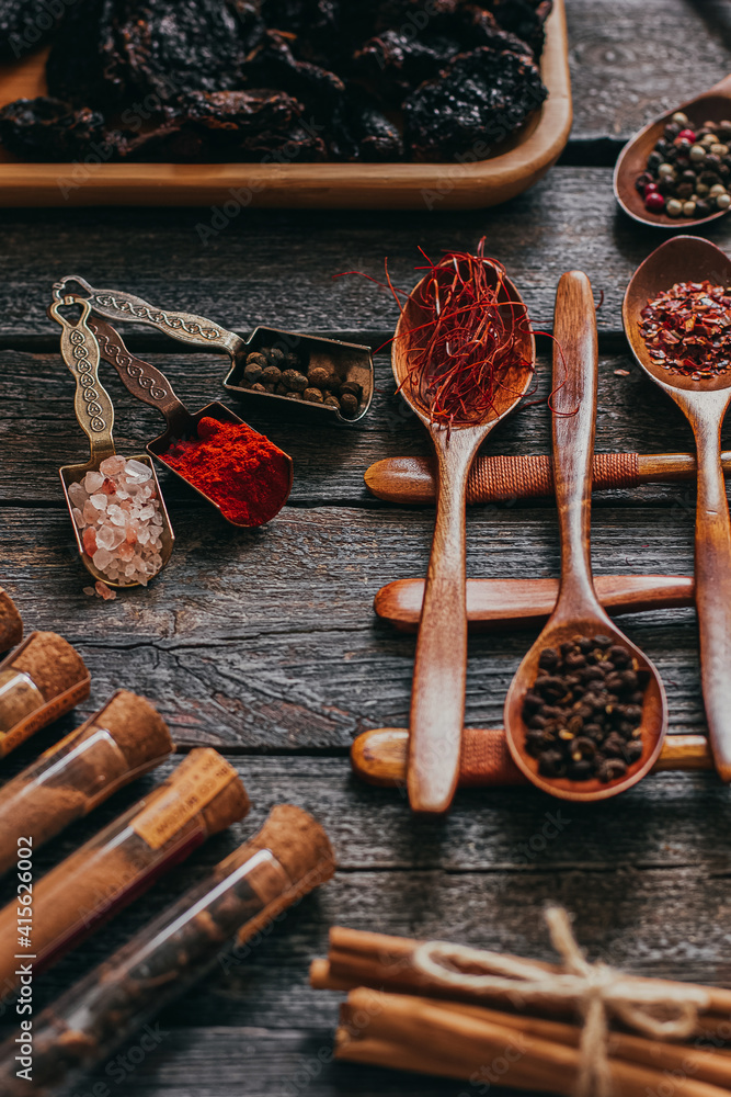 Colorful various spices in wooden spoons on old dark background. Top view with free space