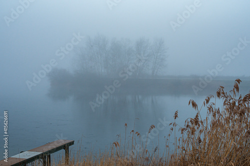 Fog on the water in Brumath, France. - Winter morning on the animation park of Brumath in Alsace. The sun is chasing the night on the lake.