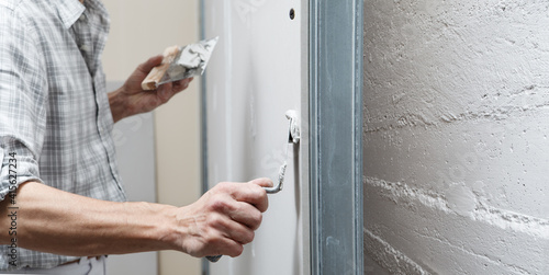 Photos closeup hands man drywall worker or plasterer putting stucco on plasterboard wal
