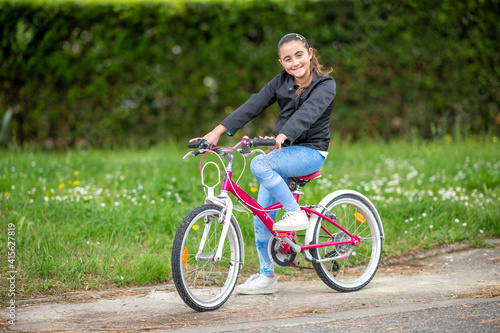 Happy young girl on teh bicycle outdoor