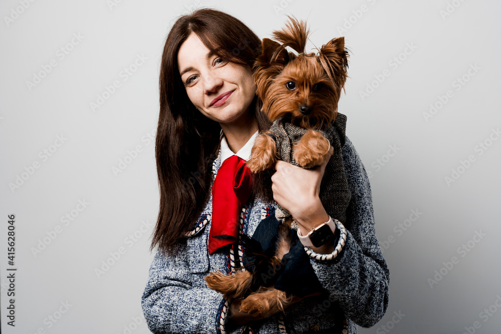 Girl holds brown dog isolated on white background. Young attractive woman with dog yorkshire terrier smiles. Close up photo. Pet care. People and pets. Girl holds brown dog isolated on white background. Young attractive woman with dog yorkshire terrier smiles. Close up photo. Pet care. People and pets.