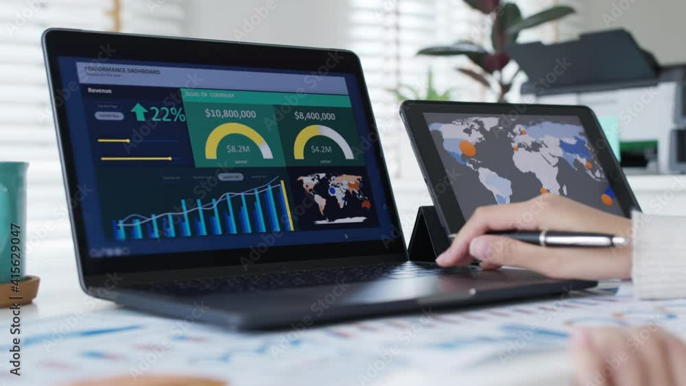 Young attractive asian thai woman employee busy work online multiple screen laptop computer or smart tablet at home in freelance sale data analytic, data science scientist engineer for business.