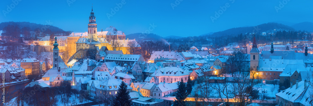 Obraz premium Panoramic view of Cesky Krumlov in winter season, Czech Republic. View of the snow-covered roofs. Travel and Holiday in Europe. Christmas time. Historical houses and streets. UNESCO World Heritage
