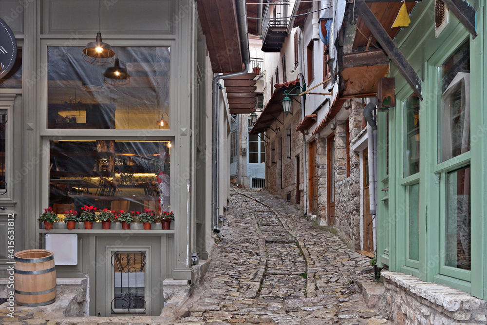 Fototapeta premium Traditional alley at Dimitsana village, an old, picturesque village in Greece, with well preserved old houses and stone paved streets.