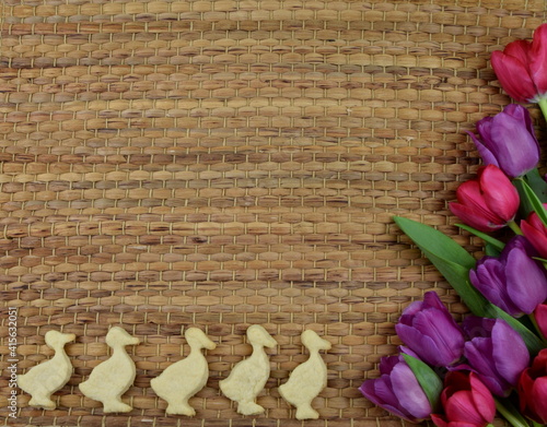 tulips and chickshaped cookies on brown background photo