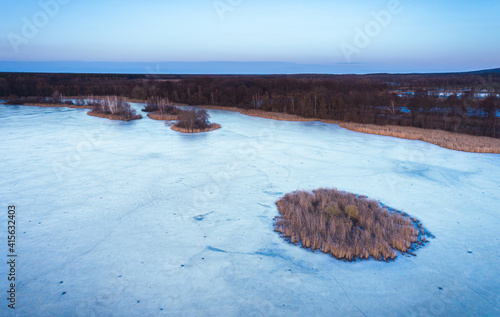 Aerial drone fly air shot, view on ice lake frozen winter top down road moody mood grey blue Saxony germany Guttau photo