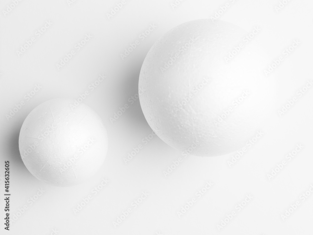 Photo two white balls, on white paper background. Soft light study Photo two white balls, on white paper background. Soft light study