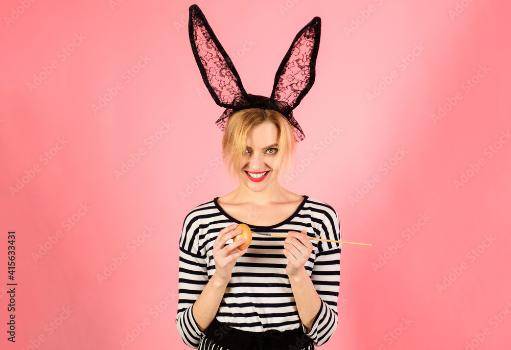 Happy easter. Woman in bunny ears painting egg, funny rabbit. Spring holidays.