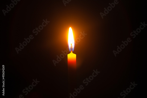 Close up single candle light and flame on black backgrou