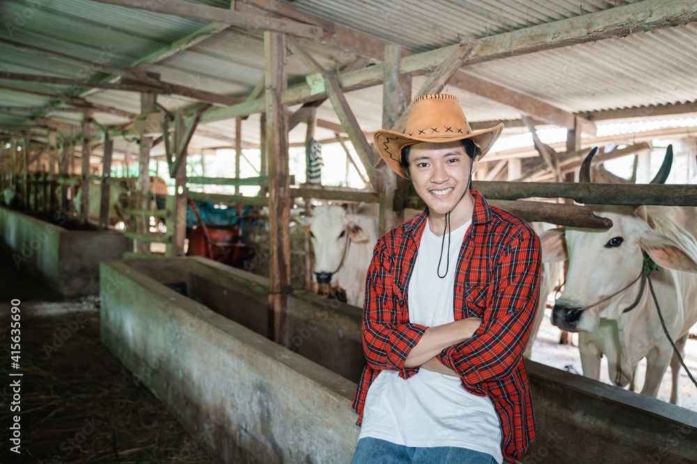 close up of male farmer wearing cowboy hat with crossed hands in the background of the cow farm stable close up of male farmer wearing cowboy hat with crossed hands in the background of the cow farm stable