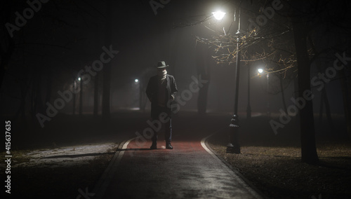 strange man on the road in the forest at night in the fog