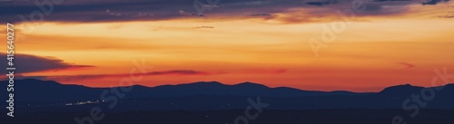 Atardecer en la Sierra de Guadarrama en Madrid, España. Cielo anaranjado con los últimos rayos del sol resaltando la silueta de las montañas ubicadas al norte de Madrid. © AngelLuis
