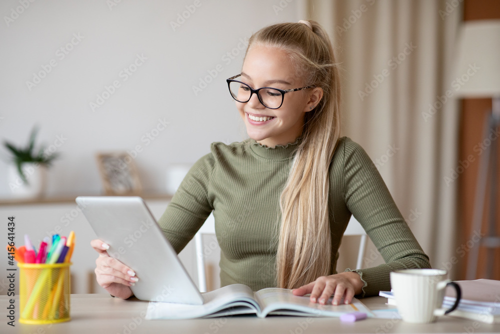 Cheerful teen girl with digital tablet screen home schooling Cheerful teen girl with digital tablet screen home schooling