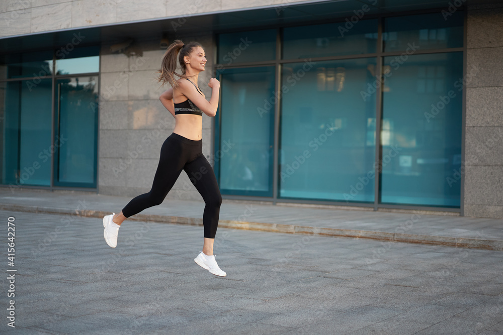 Fototapeta premium Woman running urban city street background