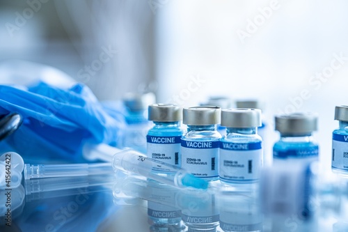 Obraz na płótnie Fight the coronavirus, sars-cov-2 pandemic. Ampoules with Covid-19 vaccine on a laboratory bench. w salonie