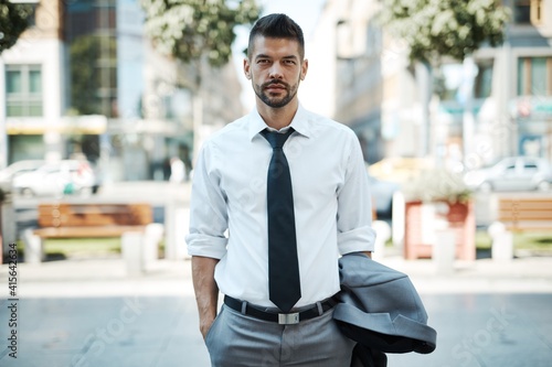 Portrait of good-looking young adult businessman outdoors on street wearing suit and tie. © nyul
