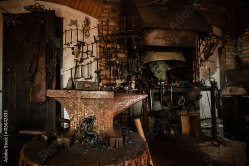 Blacksmiths tools, hammer and anvil in old Blacksmiths workshop, an ancient craft, old forge with a burned oud furnace with lots blacksmith's equipment photo