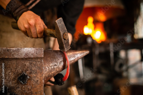 Photography A blacksmith forging horseshoe with hammer