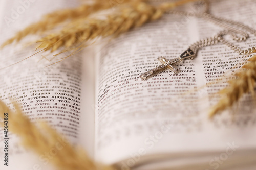 Silver necklace with crucifix cross on christian holy bible book on black wooden table Fototapet