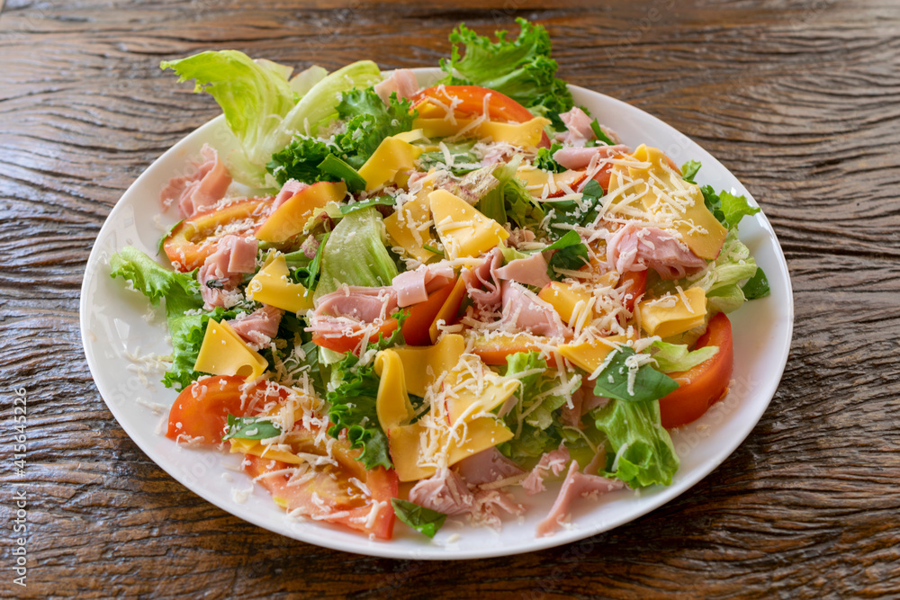 mixed salad plate with lettuce, tomato, cheese and ham.