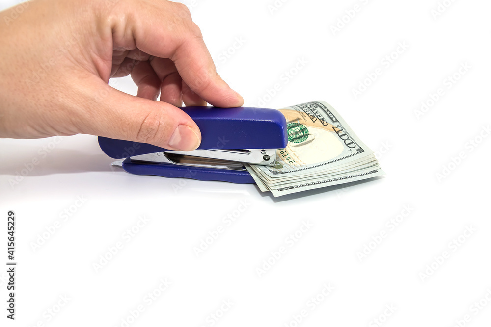 Stapler pierces dollars isolated on a white background. Punch the money with a stapler. Stapler pierces dollars isolated on a white background. Punch the money with a stapler.