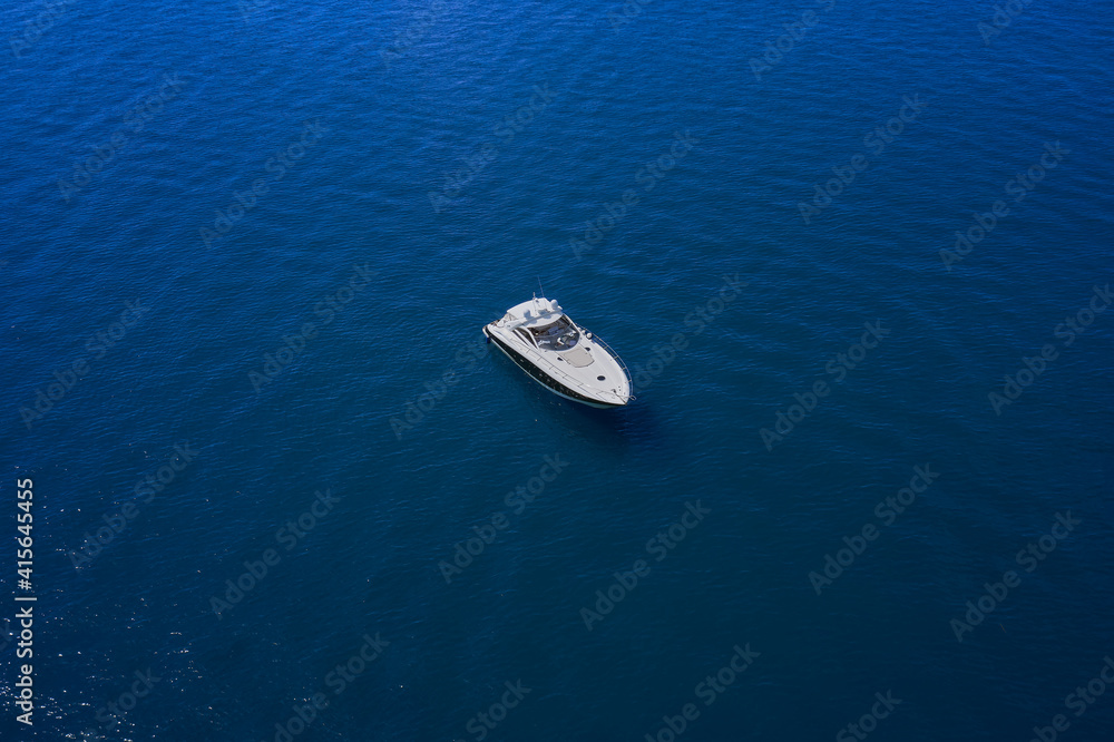 Yacht on blue water. Top view of the boat. Aerial view luxury motor boat.