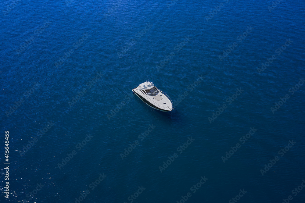 Yacht on blue water. Top view of the boat. Aerial view luxury motor boat. Yacht on blue water. Top view of the boat. Aerial view luxury motor boat.