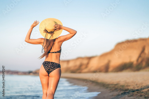 Pretty brunette woman relaxing on the beach at the sea.
