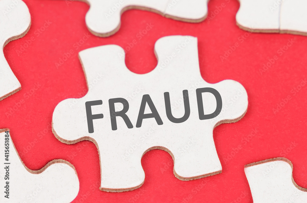 On a red background, among white puzzles lies a puzzle with the inscription - FRAUD On a red background, among white puzzles lies a puzzle with the inscription - FRAUD