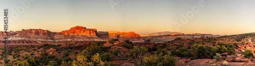 Panorama shot of red sandstone mountains and desert bushes in sunset light in capitol reef national park in Utah, america