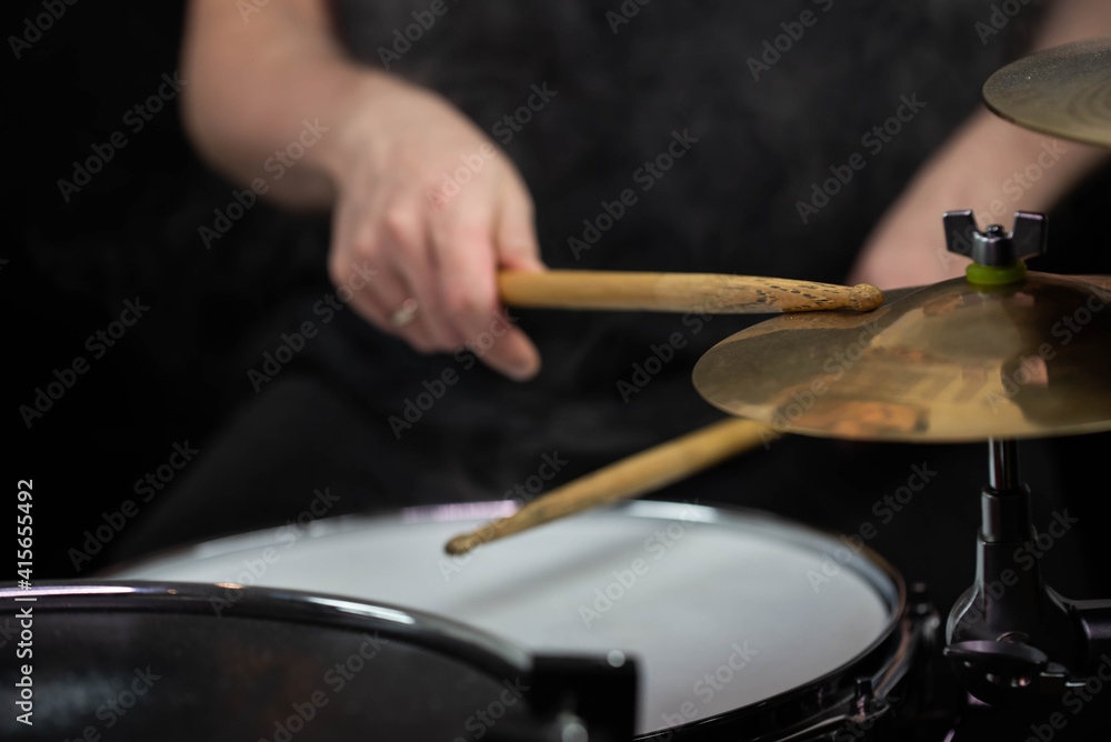Fototapeta premium Professional drum set closeup. Man drummer with drumsticks playing drums and cymbals, on the live music rock concert or in recording studio 