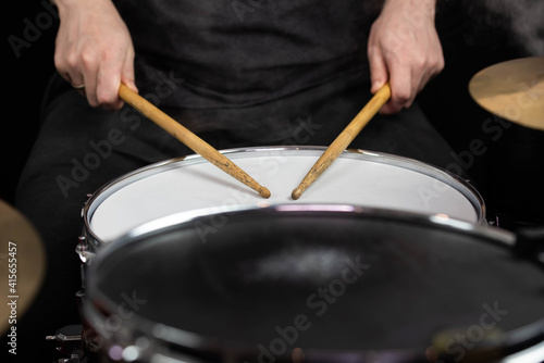 Professional drum set closeup. Man drummer with drumsticks playing drums and cymbals  on the live music rock concert or in recording studio   
