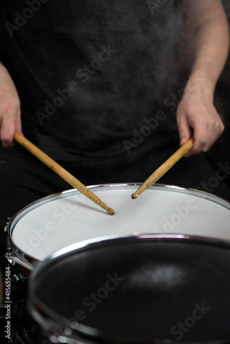 Professional drum set closeup. Man drummer with drumsticks playing drums and cymbals  on the live music rock concert or in recording studio   