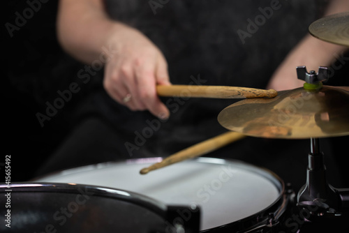 Professional drum set closeup. Man drummer with drumsticks playing drums and cymbals, on the live music rock concert or in recording studio 