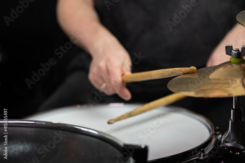 Professional drum set closeup. Man drummer with drumsticks playing drums and cymbals, on the live music rock concert or in recording studio 