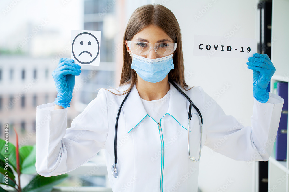 Doctor holding a paper card with text covid-19