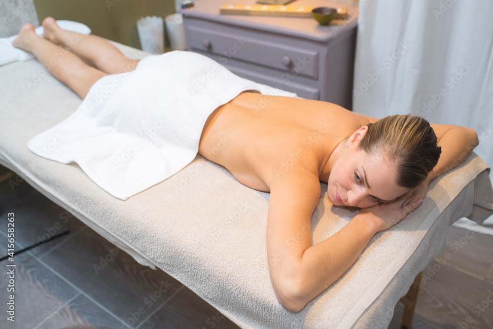 woman layed waiting face down on couch at spa resort