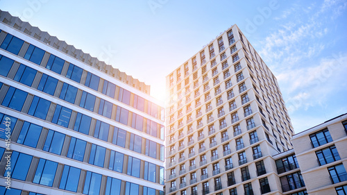 Downtown corporate business district architecture. Glass reflective office buildings against blue sky and sun light. Economy  finances  business activity concept. Rising sun on the horizon.