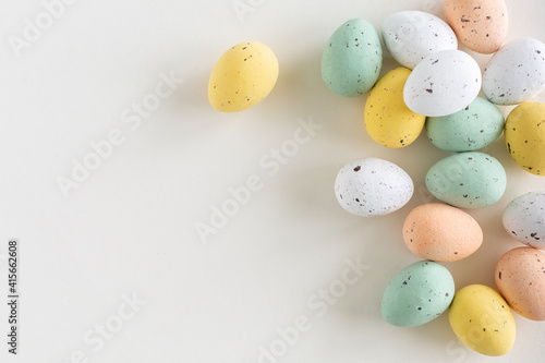 Canvas Print Chocolate easter egg in pastel colors on a white background, flat lay with copy
