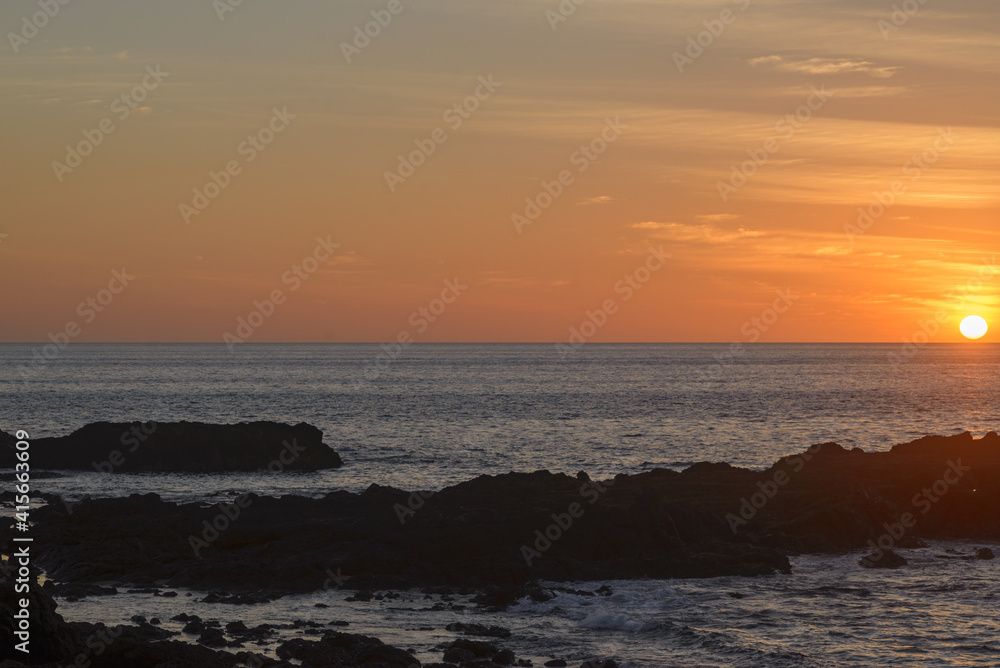 Sun setting on a rocky beach